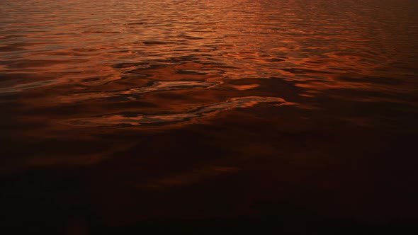 Water Surface of a River on a Sunset with Bright Orange Reflections