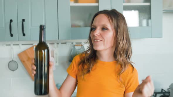 A Beautiful Woman in White Shorts is Relaxing at Home Dancing in the Kitchen