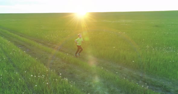 Sporty Child Runs Through a Green Wheat Field