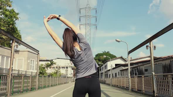 Beautiful young Asian woman stretching and warming before running a Jogging workout.