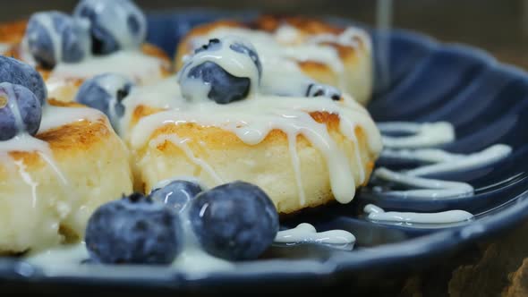 Pour Condensed Milk on Cottage Cheese Pancakes with Berries in a Bowl