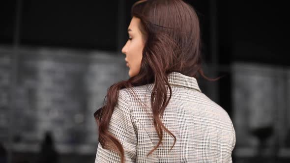 Gorgeous Girl with Long Hair Looking at Camera in the Wind