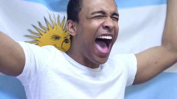 Argentinian Fan Celebrating While Holding the Flag of Argentina in Slow Motion