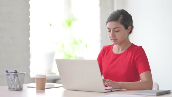 Indian Woman Showing Thumbs Up Sign While Using Laptop in Office