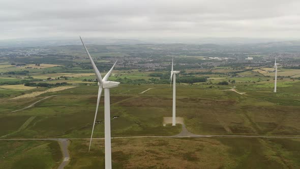 Drone footage over wind turbines in a countryside setting