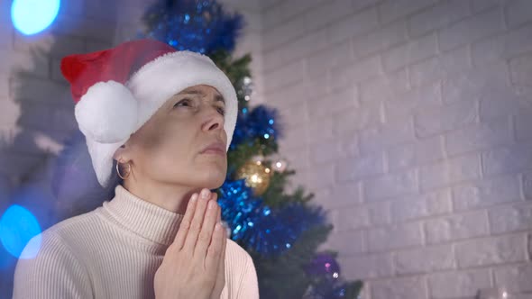 Alone woman make a wish by Christmas tree.