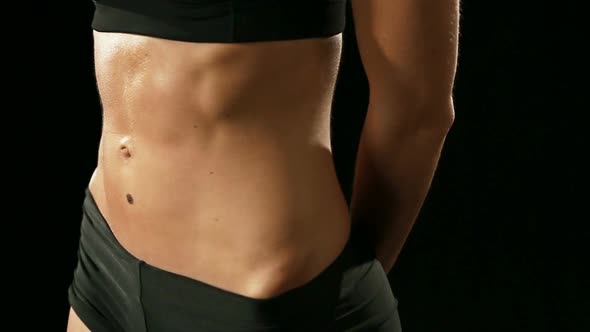 Young Athletic Woman Wearing Sporstwear is Warming Up Isolated on Black