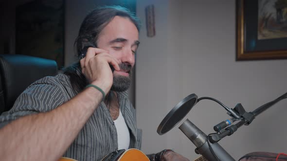 Music Influencer Talking with His Phone at His Home Studio