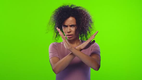 Annoyed Dark-skinned Woman Making Stop Gesture with Her Hands, Saying No