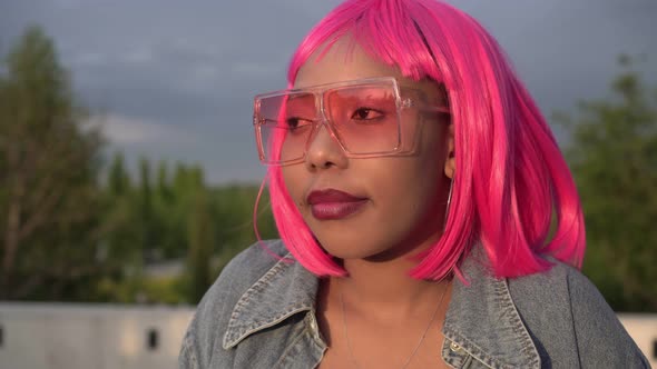 Young Pensive Black African Woman with Pink Hair Outdoors