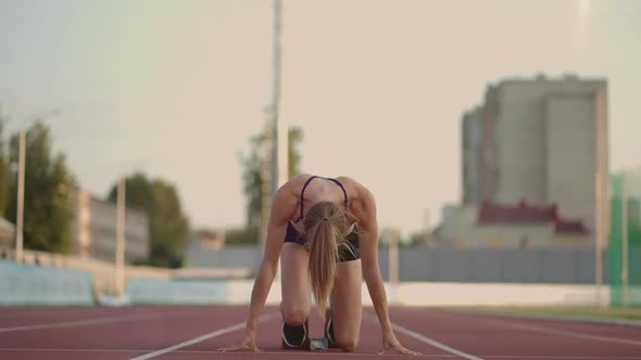 Caucasian Young Brunette Woman Shit for a Run in the Stadium Comes Up to the Running Sides and