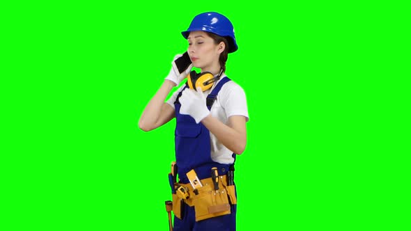 Engineer Is Standing and Talking on the Phone with a Drawing in Her Hands, Green Screen