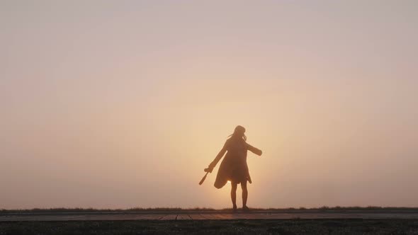 Stunning Wide Background Shot of Happy Woman Spinning Excited at Breathtaking Pink Foggy Sunset