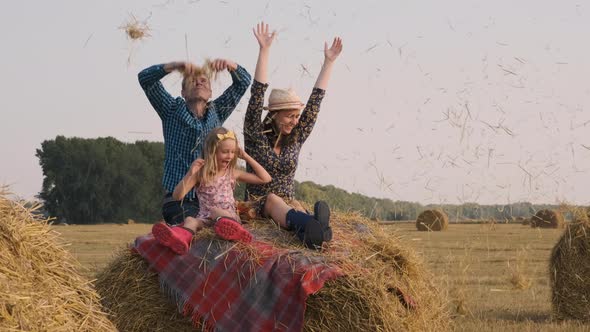 Young Family Having Fun on a Hay Bale