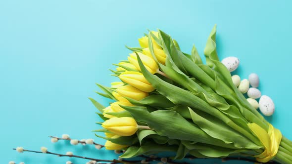 Holiday Contept Decoration with Easter Eggs and Yellow Tulips Over Blue