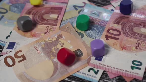 On a pile of euro banknotes, 6 multi-colored dice fall.