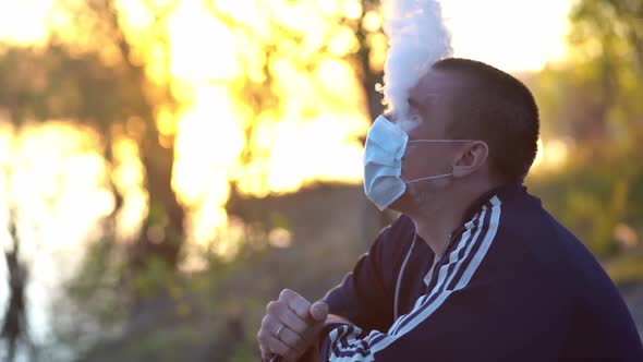 Man Lets Out Smoke From Under a Medical Mask on His Face