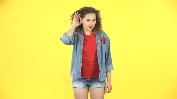 Woman Does Not Hear Anything, Shows His Hands Emotions on Yellow Background