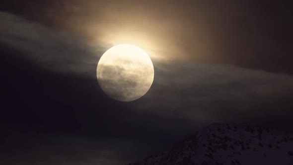 Full Moon reflecting on passing clouds