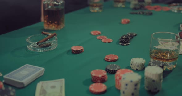 On a Green Gaming Table are Chips Money Cards and Cigars of Players