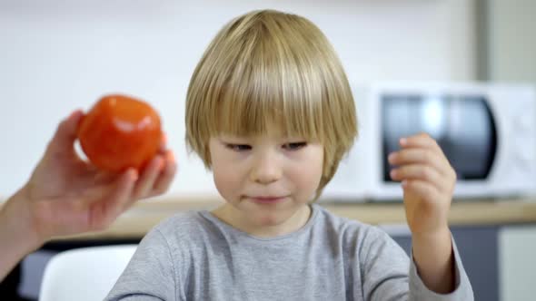 Closeup Portrait of Cute Blond Little Boy with Blue Eyes Having Breakfast in the Morning