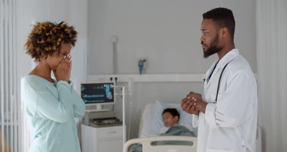 African Doctor Telling Bad News To Mother of Sick Kid Lying in Hospital Bed