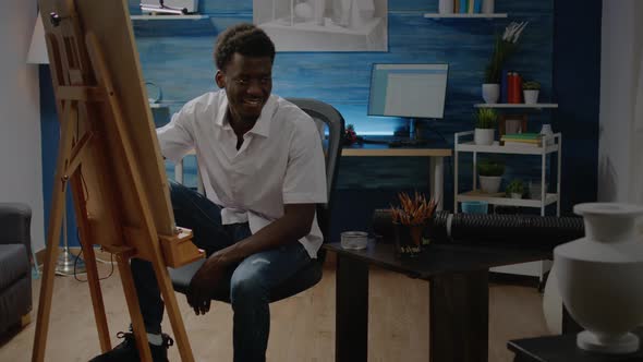 African American Adult Sitting in Artwork Studio Drawing