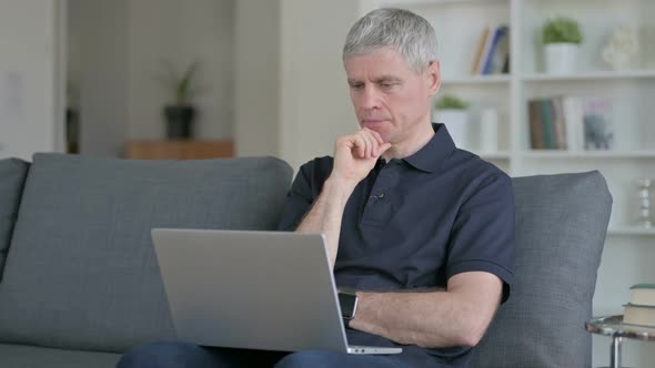 Professional Middle Aged Businessman Using Laptop on Sofa