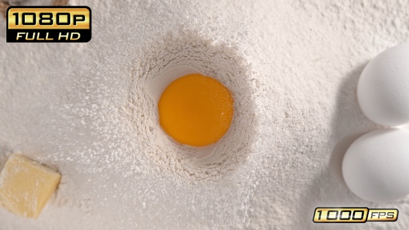 Raw Egg Yolk Falling into Flour