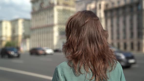 Portrait of a Cheerful Middle-aged Woman with Brown Hair, Walking Through the City Along the Highway