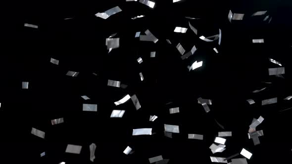 Silvery Ribbons of Confetti Falling Down on an Isolated Black Background