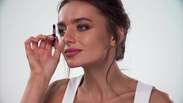 Eyebrows Makeup. Woman Combing Eyebrow With Brush Closeup