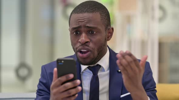 Portrait of African Businessman Having Loss on Smartphone