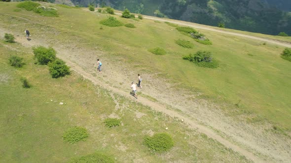 Aerial View of Tourists Walk Along a Path on a Green Hill in Balkan Mountains