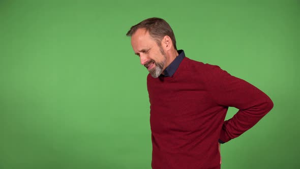 A Middleaged Handsome Caucasian Man Has Back Pain  Green Screen Background