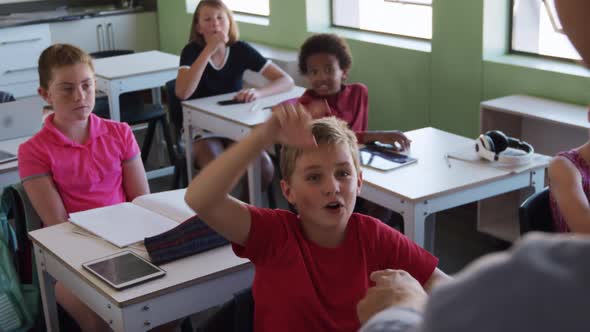 Boy raising his hands in the class