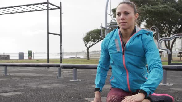 Sporty Caucasian woman exercising in an outdoor gym during daytime