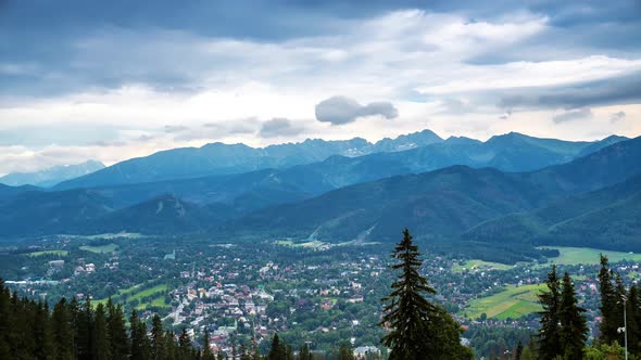 top of Poland Mountains mount gubalowka looking at Tatra Mountains town below with rolling clouds lo