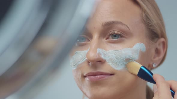 Blonde Model in Studio Makes a Cleansing Facial Mask