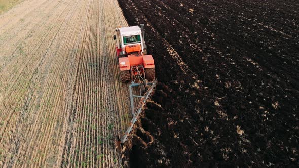 Tractor Plowing Fields, Preparing Land for Sowing. Aerial View. Farmer in Tractor Preparing Land in