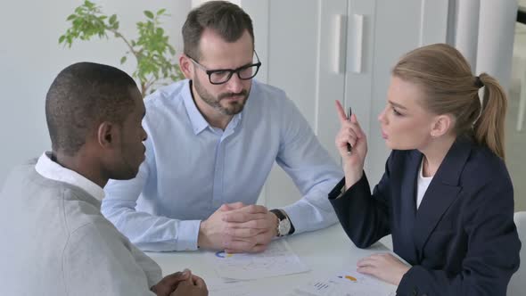 Businesswoman Scolding Colleagues While Discussing Documents