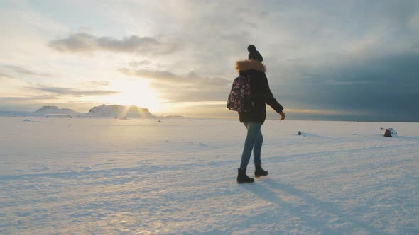Yong Beautiful Woman Traveler Walking on Snow Desert in Iceland