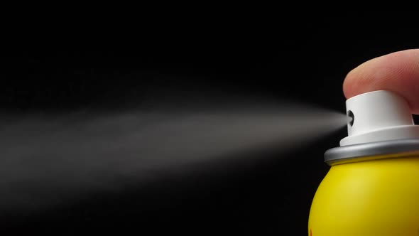Slow motion of spray bottle drops on black background. Male perfume bottle on a dark background