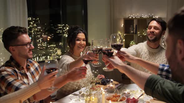 Happy Friends Drinking Red Wine at Christmas Party