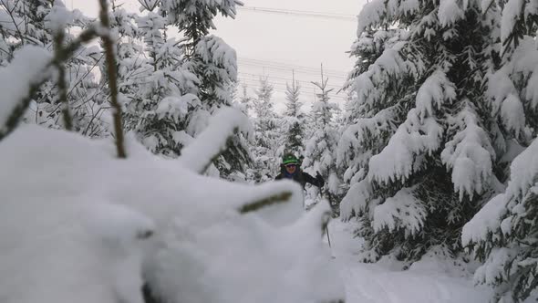 Man Ski Touring With Poles Through Snow Covered Forest