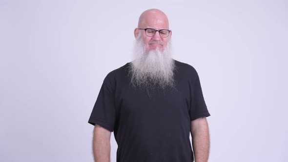 Sad Mature Bald Bearded Man Looking Upset and Giving Thumbs Down