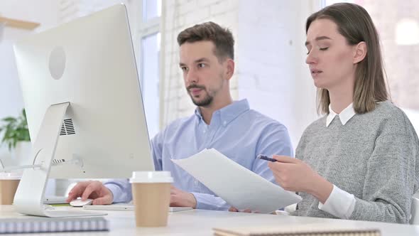 Disappointed Creative Team Having Failure By Doing Paperwork on Desktop