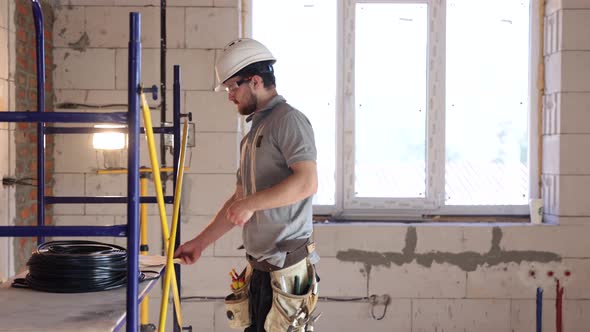 Electrician contractor with electric cable at a construction site.