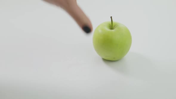 Hand Moving Away Pills Putting Green Healthful Vitamin Apple on White Table