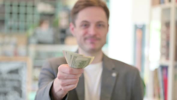 Portrait of Young Man Giving Away Dollars